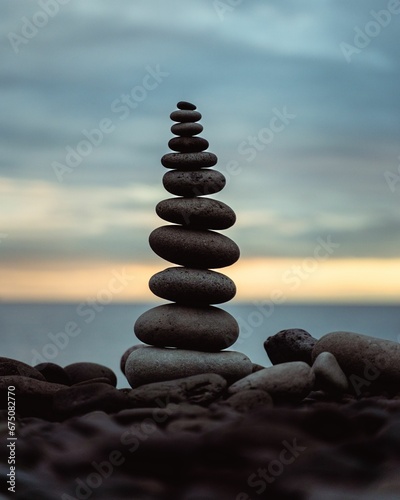 Scenic ocean view featuring a collection of stacked rocks in a yoga formation © Wirestock
