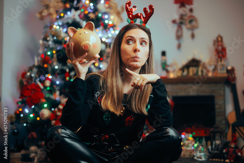 Fotografia Funny Christmas Woman Pointing to a Piggy Bank