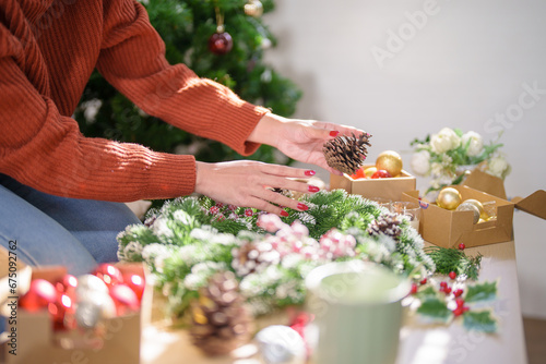 Woman making mistletoe wreath Christmas wreath decoration with hand made DIY winter greenery florist hands making Christmas wreath beautiful mistletoe.