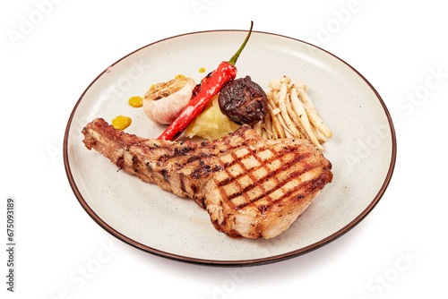 Pork chop steak (tomahawk) served with shimeji mushrooms, shiitake mushrooms, garlic and grilled chilies, mustard and mashed potatoes isolated on white background.