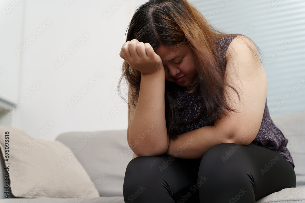 Sad Overweight plus size woman thinking about problems on sofa upset girl feeling lonely and sad from bad relationship or Depressed woman disorder mental health Sad Overweight plus size woman thinking about problems on sofa upset girl feeling lonely and sad from bad relationship or Depressed woman disorder mental health