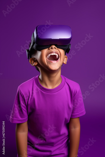 Young boy getting experience using VR headset glasses isolated on a purple background