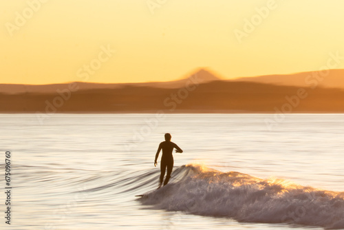 Vertical of surfer Silhouette at sunset at Noosa QLD