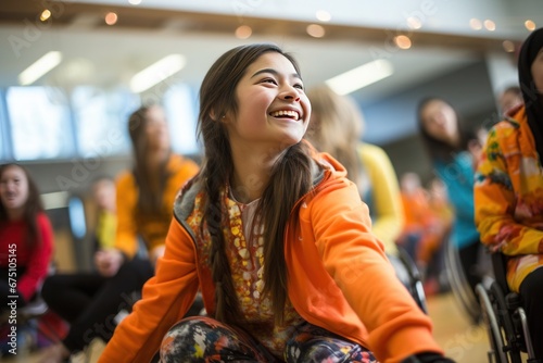 A happy and smiling schoolgirl with mobility challenges, using a wheelchair, enjoys a physical education class at school