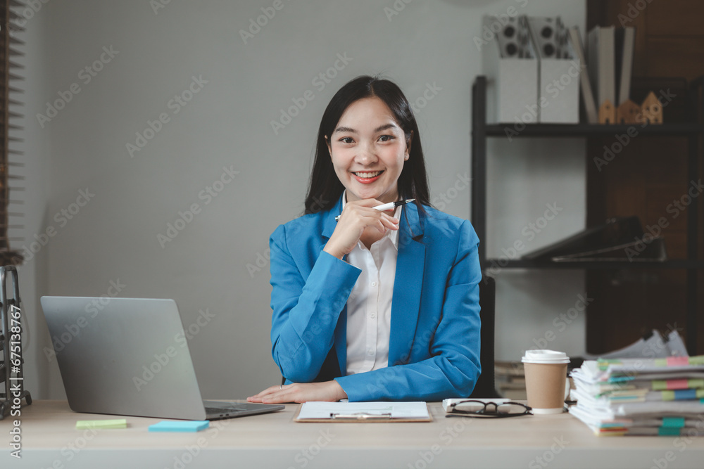 Business woman is sitting and working in the office, employee is looking for information on laptop, Recording various information on paper, office idea.