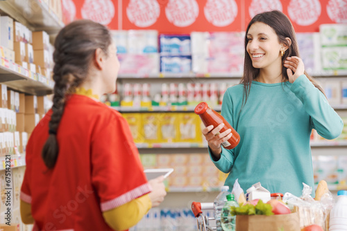 Friendly supermarket clerk and customer talking together