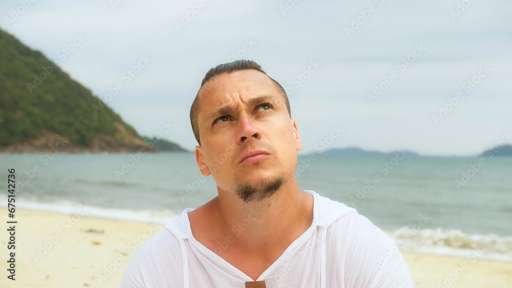 Close-up portrait man apply sun cream protection lotion, looking at camera.Stylish men on beach near sea smearing sunscreen cream in style war paint.Person applying sunscreen on face.Facial skin care