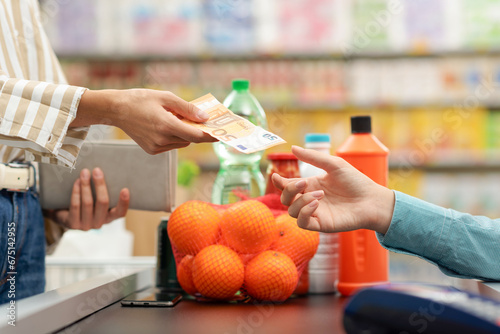Woman paying for her groceries at the supermarket checkout