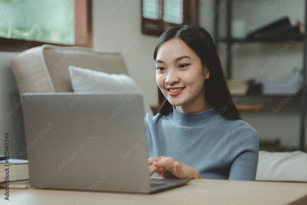 A student is sitting in the living room doing homework, Sitting and looking for information and making reports to send to teachers in the house, Recording various information In the book at apartment. A student is sitting in the living room doing homework, Sitting and looking for information and making reports to send to teachers in the house, Recording various information In the book at apartment.