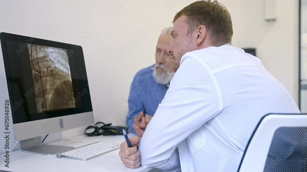 An elderly patient at a cardiologist's appointment examines the heart vessels on a screen in a modern medical center An elderly patient at a cardiologist's appointment examines the heart vessels on a screen in a modern medical center