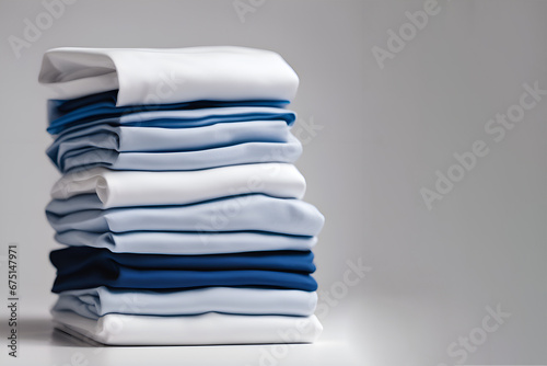 Blue and white T-shirts lie in a stack.