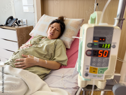 pregnant woman patient has a stomachache on bed in hospital