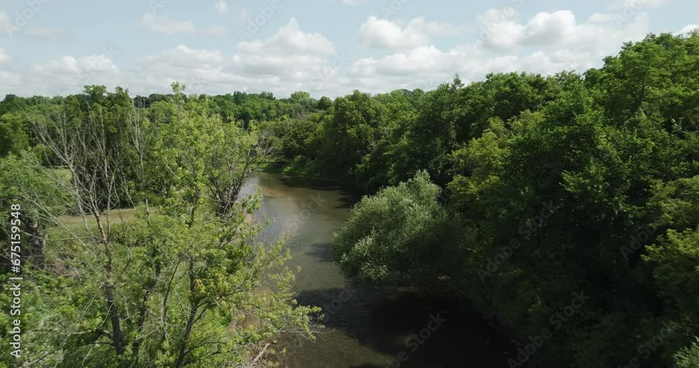 Beautiful fast aerial shot flying above Zumbro river surrounded by trees, USA Beautiful fast aerial shot flying above Zumbro river surrounded by trees, USA