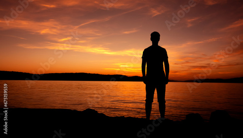 sylwetka mężczyzny medytującego na plaży przy zachodzie słońca