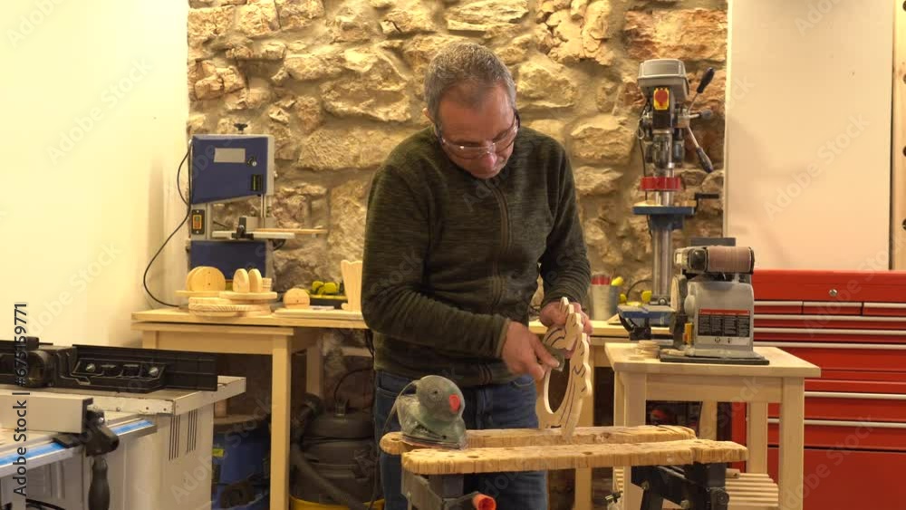 Carpenter polishing a piece of wood in workshop Carpenter polishing a piece of wood in workshop