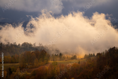 Dramatic landscape with fog in the mountains during the sunset.