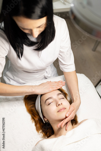 Young woman enjoying massage in spa salon. Face massage. Closeup of young woman getting spa massage treatment at beauty spa salon.Spa skin and body care. Facial beauty treatment.Cosmetology. . High qu