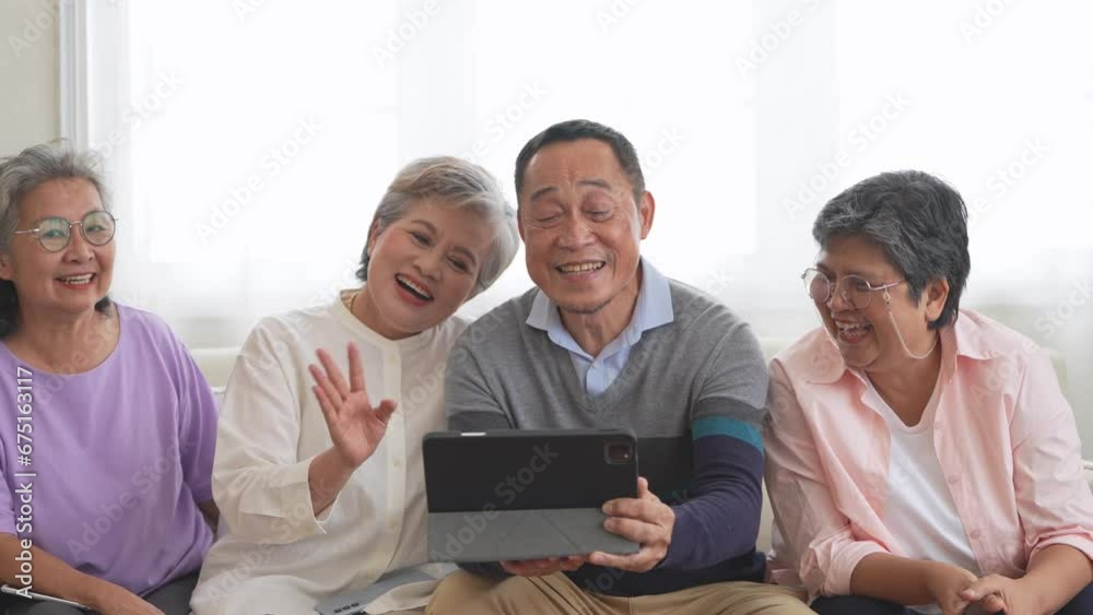 Happiness of the group females and male elderly talking with Video Call from smart tablet. Senior people are talking and enjoy together at the living room. Joyful retired friends enjoying relaxation. Happiness of the group females and male elderly talking with Video Call from smart tablet. Senior people are talking and enjoy together at the living room. Joyful retired friends enjoying relaxation.