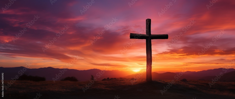 Silhouette of a cross on against a colorful sunset sky