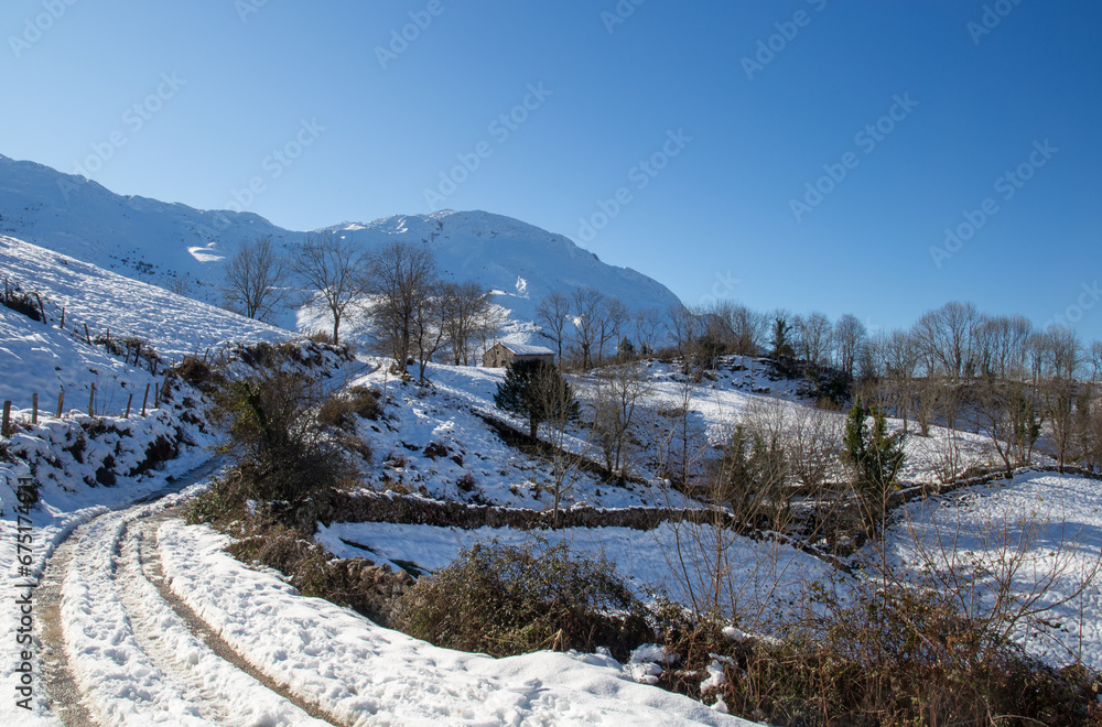 road leading to a wooden hut in the mountain surrounded by snow