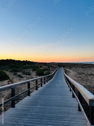 Boardwalk to the ocean  orange horizon  blue pure sky  no people