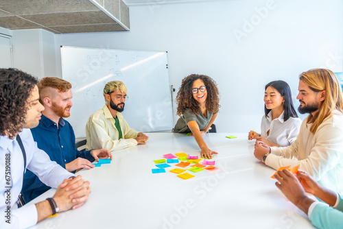 Woman reading adhesive notes during a brainstorming in a meeting