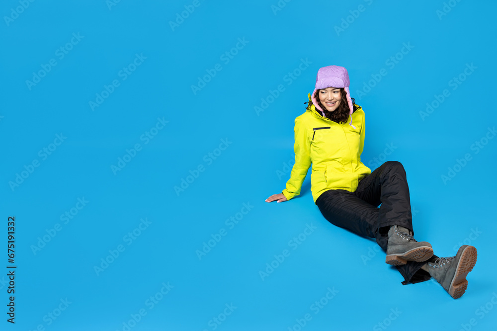 Obraz premium A girl in a ski suit on a blue background.