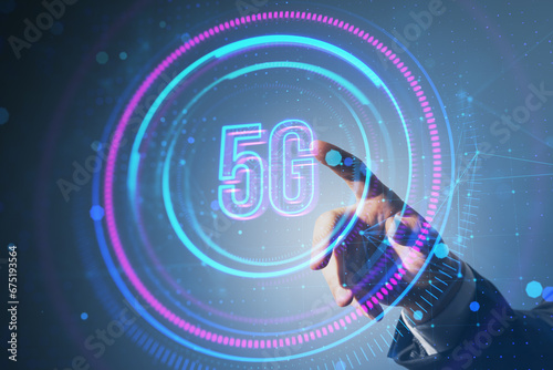 Close up of businessman hand pointing at glowing round 5G hologram on blurry background. Telecommunication and internet speed concept. Double exposure.