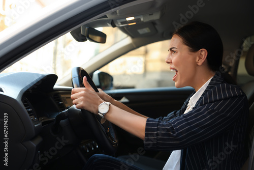 Angry driver screaming in her car. Stuck in traffic jam © New Africa