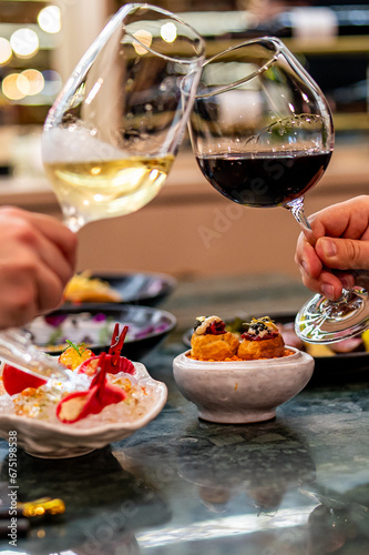 Close up of hands young couple man and woman clinking with glasses of red and white wine at restaurant