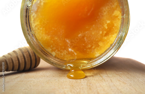 Billede på lærred Drop leaking from a jar of crystallized honey