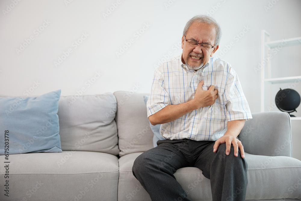 senior elderly man have a chest pain or suffering from heart attack on a sofa senior elderly man have a chest pain or suffering from heart attack on a sofa