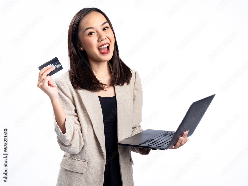 Naklejka premium A portrait of an Indonesian Asian woman wearing a cream-colored blazer, using a laptop, and showing a card. Isolated against a white background.