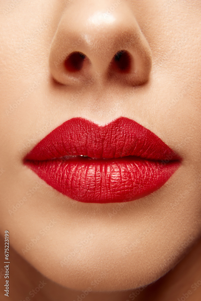 Extreme close up photo of full plump bright red female lips. Mouth clothed. Lip matte lipstick. Skin care routine. Extreme close up photo of full plump bright red female lips. Mouth clothed. Lip matte lipstick. Skin care routine.