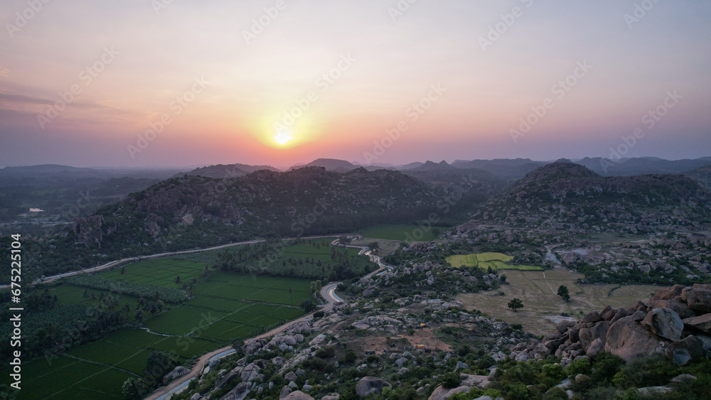 Fototapeta premium A beautiful view of a sunset or sunrise over rocky hills or mountains from the top