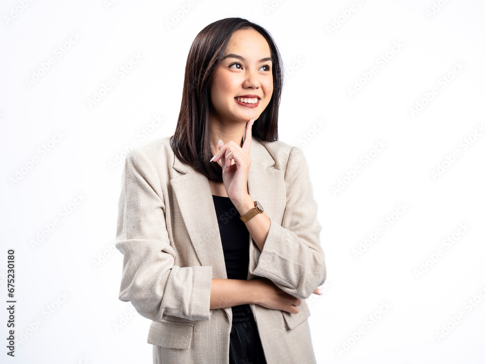 Portrait of an Indonesian Asian woman wearing a cream blazer, posing happily with an index finger on her cheek. Isolated against a white background. Portrait of an Indonesian Asian woman wearing a cream blazer, posing happily with an index finger on her cheek. Isolated against a white background.
