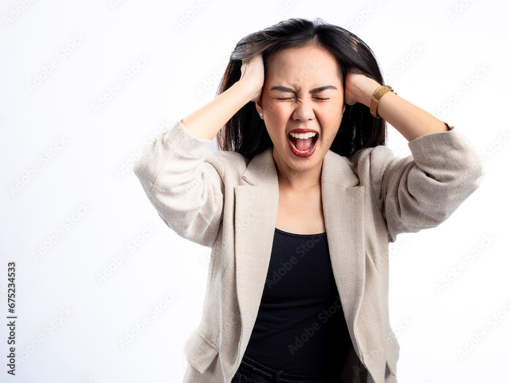 A portrait of an Indonesian Asian woman wearing a cream-colored blazer, feeling emotional, having a headache, and holding her head. Isolated against a white background. A portrait of an Indonesian Asian woman wearing a cream-colored blazer, feeling emotional, having a headache, and holding her head. Isolated against a white background.