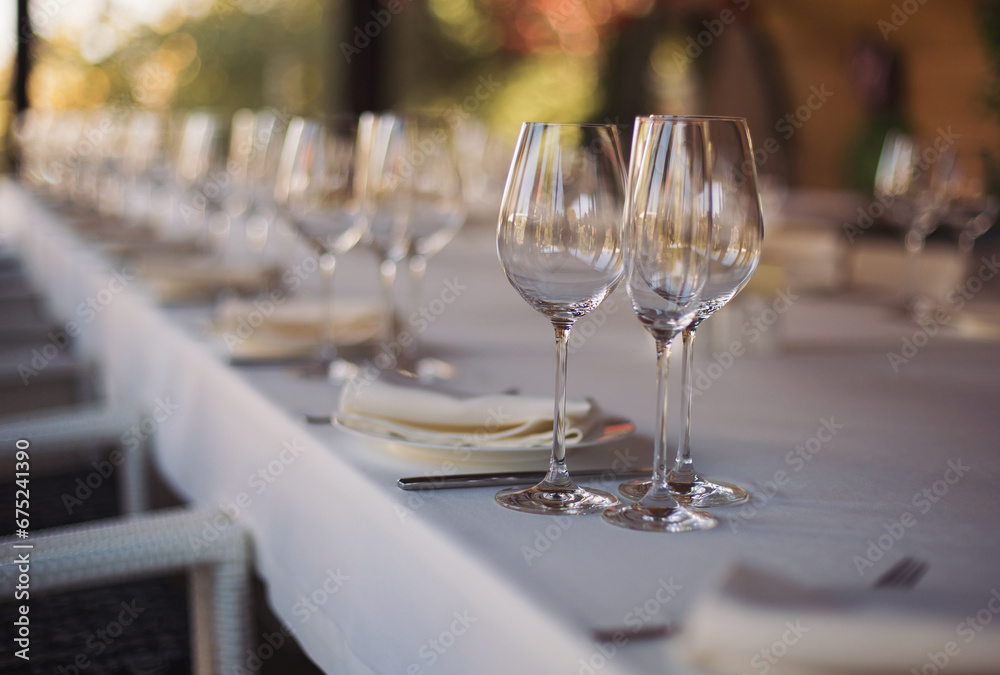 elegant dinner table setting in restaurant or hotel with wine glasses. tableware Glasses, flower fork, knife served for dinner in restaurant elegant dinner table setting in restaurant or hotel with wine glasses. tableware Glasses, flower fork, knife served for dinner in restaurant