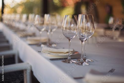 elegant dinner table setting in restaurant or hotel with wine glasses. tableware Glasses  flower fork  knife served for dinner in restaurant