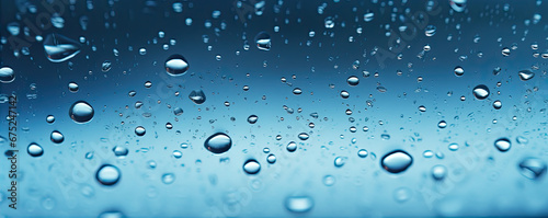 Water or oil drops on glass surface in blue colors. Dropslet close up.