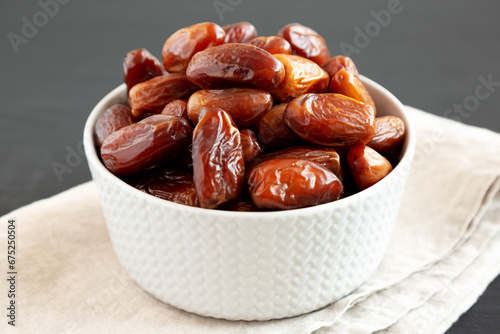Organic Dry Deglet Nour Dates in a Bowl, side view. Close-up.