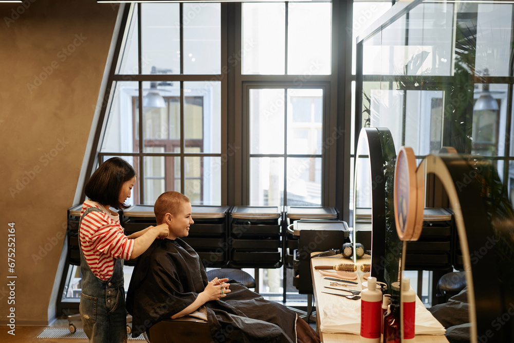 Wide angle view of modern loft style beauty salon with tall glass windows, copy space