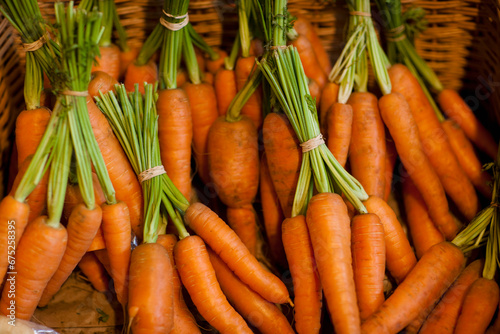 Close up of a basket filled with trimmed bunches of carrots
 photo