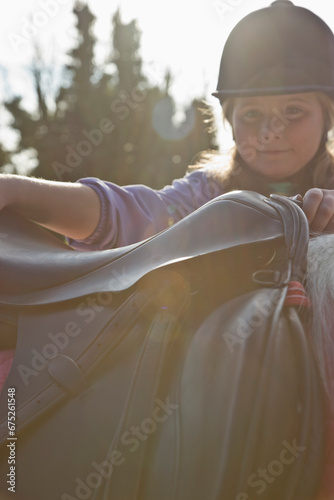 Young girl getting on a horse
 photo