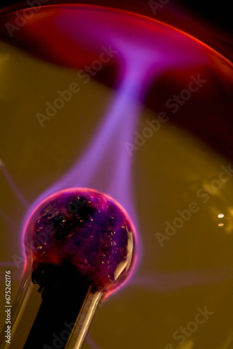 Plasma ball with red purple and pink electrical discharge
 photo