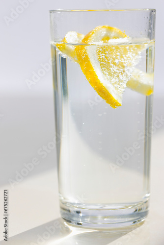 Close up of a glass of sparkling water and sliced lemon
 photo