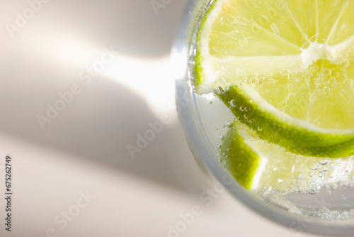 Extreme close up of a glass of sparkling water with sliced lime
