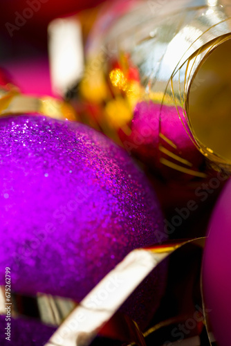 Extreme close up of a purple Christmas bauble and a gold ribbon
