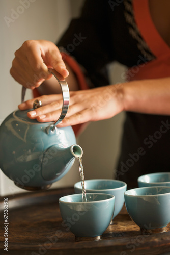 Close up of a woman hands pouring green tea
