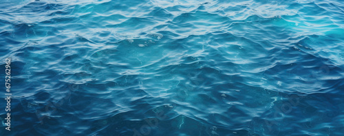 Blue sea water surface with sun glare and ripple background © Jasmina